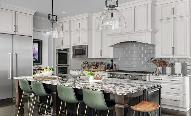 3530 Trimble Ct, Nashville, TN 37215 - kitchen with built in appliances, white cabinetry, light stone countertops, decorative backsplash, and a center island with sink