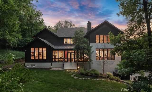 3530 Trimble Ct, Nashville, TN 37215 - rear view of property featuring a sunroom, a chimney, a lawn, a standing seam roof, and a metal roof