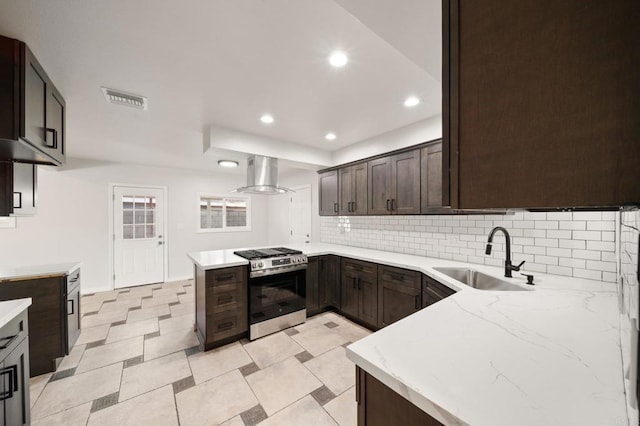 11233 Mountain, Riverside, CA 92505 - kitchen with stainless steel range with gas stovetop, exhaust hood, dark brown cabinets, tasteful backsplash, and recessed lighting