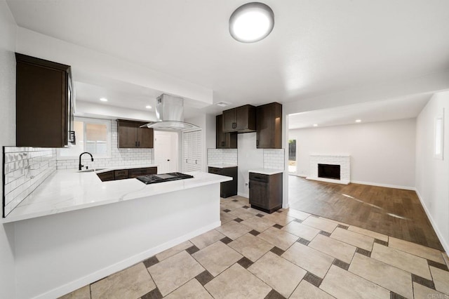 11233 Mountain, Riverside, CA 92505 - kitchen featuring island exhaust hood, dark brown cabinetry, backsplash, a peninsula, and plenty of natural light