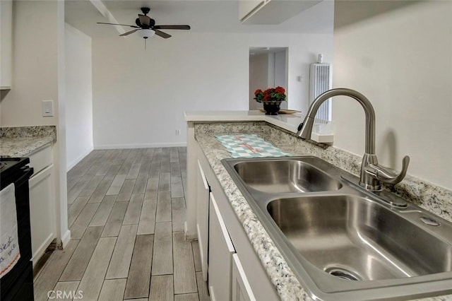 23318 Sesame St Unit E, Torrance, CA 90502 - kitchen with wood finished floors, ceiling fan, white cabinets, black range with electric cooktop, and light stone counters
