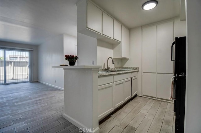 23318 Sesame St Unit E, Torrance, CA 90502 - kitchen with wood finish floors, white cabinetry, and a peninsula