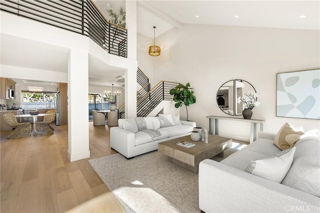11 Thunder Trl Unit 6, Irvine, CA 92614 - living room with stairs, light wood-type flooring, a chandelier, and high vaulted ceiling