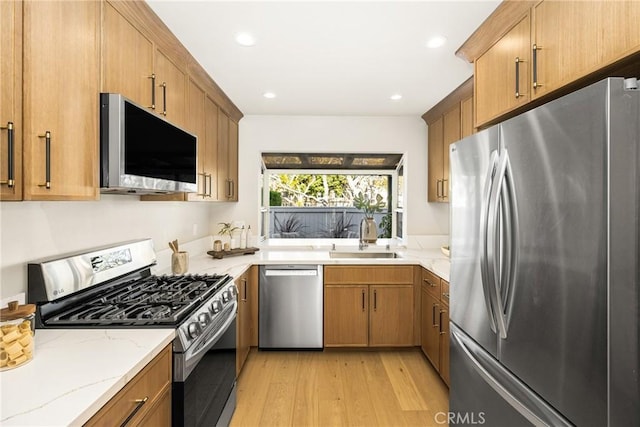 11 Thunder Trl Unit 6, Irvine, CA 92614 - kitchen featuring stainless steel appliances, light wood-style flooring, light stone countertops, brown cabinets, and recessed lighting