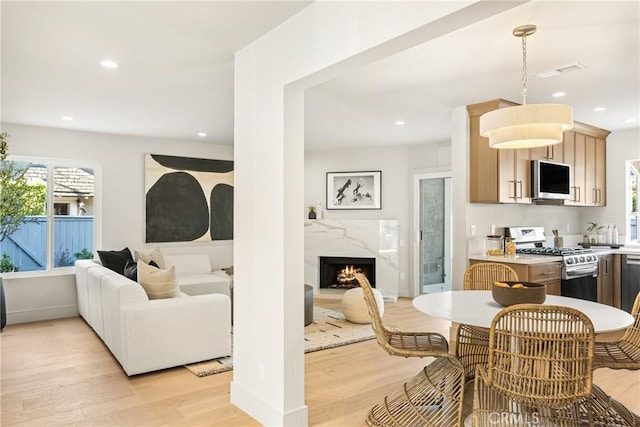 11 Thunder Trl Unit 6, Irvine, CA 92614 - dining space featuring light wood-style floors, recessed lighting, and a high end fireplace