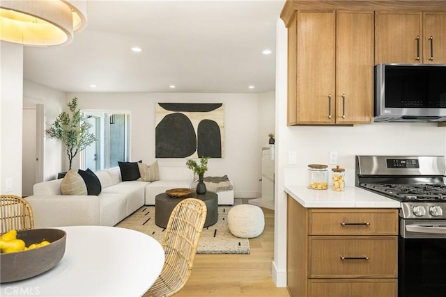 11 Thunder Trl Unit 6, Irvine, CA 92614 - kitchen featuring appliances with stainless steel finishes, light wood-style floors, open floor plan, light countertops, and recessed lighting