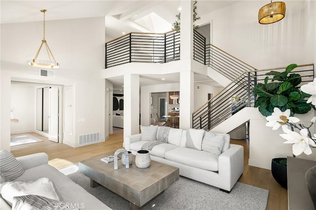 11 Thunder Trl Unit 6, Irvine, CA 92614 - living room featuring light wood-style flooring, stairs, and a towering ceiling