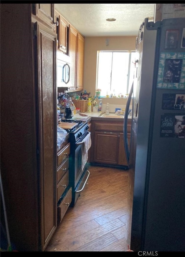 20823 Plum Cyn, Saugus, CA 91350 - kitchen with stainless steel appliances, light wood-type flooring, brown cabinets, light countertops, and a textured ceiling
