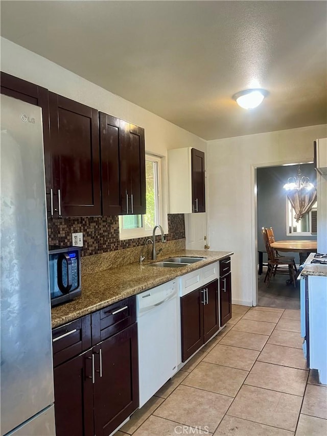 5617 29th St, Jurupa Valley, CA 92509 - kitchen featuring dishwasher, freestanding refrigerator, decorative backsplash, and stone countertops