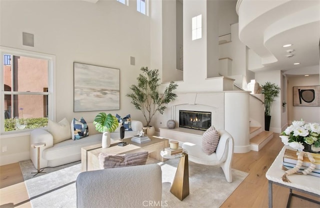 7 Suprema Dr, Newport Coast, CA 92657 - living room featuring a high ceiling, light wood-style floors, healthy amount of natural light, and stairway