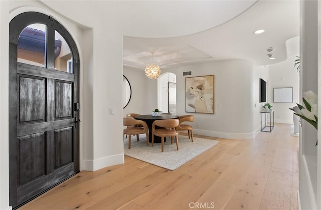 7 Suprema Dr, Newport Coast, CA 92657 - entryway with light wood-type flooring, recessed lighting, arched walkways, a raised ceiling, and a chandelier