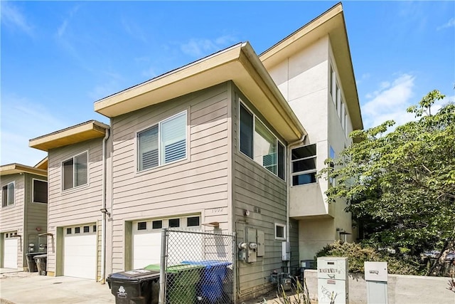 1002 Leighton Ave, Los Angeles, CA 90037 - view of side of home featuring an attached garage and concrete driveway