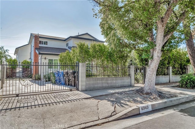 6943 Goodland Ave, North Hollywood, CA 91605 - view of property hidden behind natural elements with stucco siding, a gate, and a fenced front yard