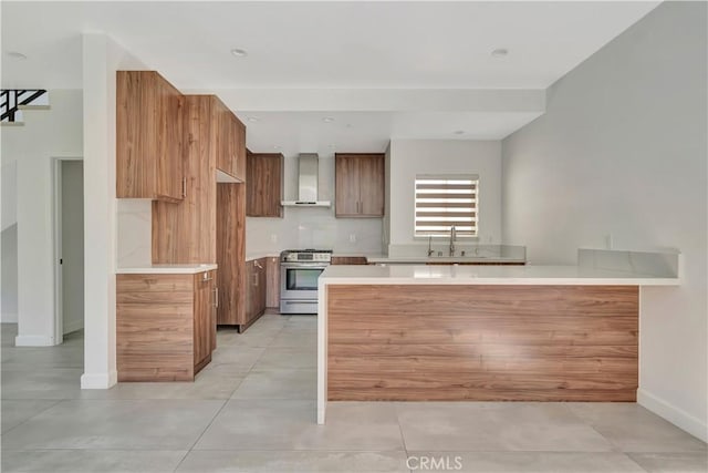 6943 Goodland Ave, North Hollywood, CA 91605 - kitchen with gas stove, wall chimney range hood, brown cabinets, a peninsula, and light countertops
