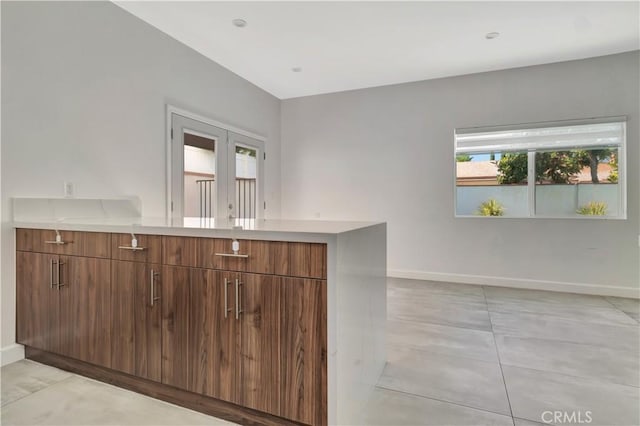 6943 Goodland Ave, North Hollywood, CA 91605 - kitchen featuring light countertops, a peninsula, brown cabinetry, and modern cabinets