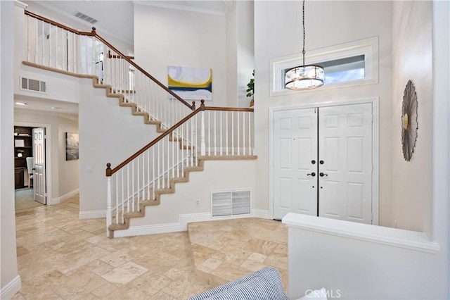 18 Via Tigra, Rancho Santa Margarita, CA 92688 - foyer entrance featuring a towering ceiling, stairway, a chandelier, stone finish floors, and ornamental molding