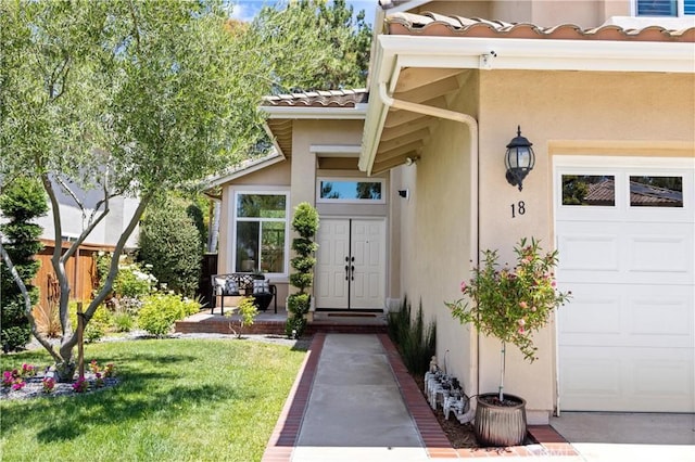 18 Via Tigra, Rancho Santa Margarita, CA 92688 - property entrance with stucco siding, a tiled roof, a garage, and a lawn