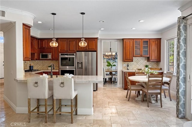 18 Via Tigra, Rancho Santa Margarita, CA 92688 - kitchen featuring appliances with stainless steel finishes, a peninsula, brown cabinets, decorative backsplash, and ornamental molding