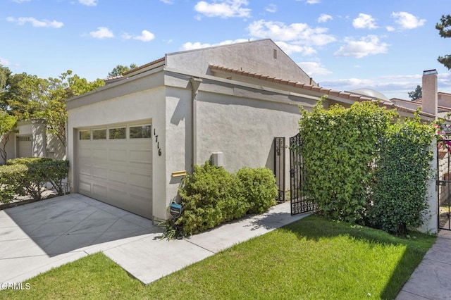 1716 Shoreline St, Camarillo, CA 93010 - view of side of home featuring stucco siding, an attached garage, concrete driveway, a gate, and a yard
