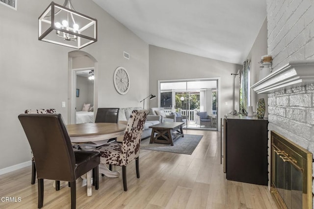 1716 Shoreline St, Camarillo, CA 93010 - dining room featuring high vaulted ceiling, arched walkways, light wood finished floors, a chandelier, and a glass covered fireplace