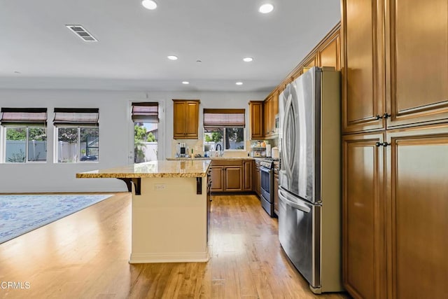665 Tiber River Way, Oxnard, CA 93036 - kitchen featuring appliances with stainless steel finishes, a kitchen bar, brown cabinetry, a center island, and recessed lighting