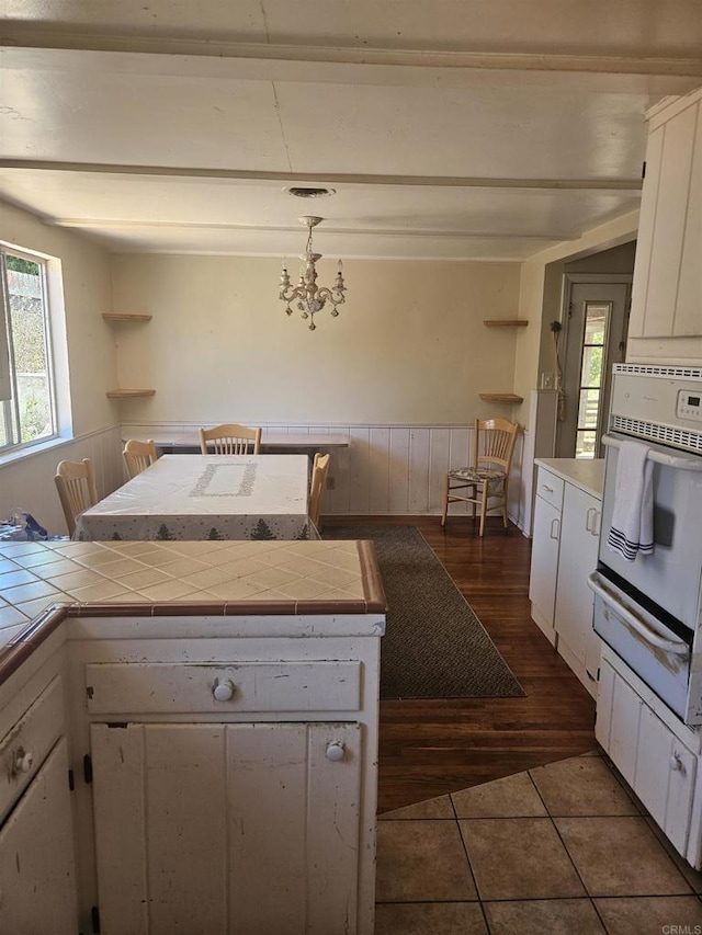 733 Cathy, Cardiff By The Sea, CA 92007 - kitchen with a warming drawer, white oven, tile countertops, white cabinets, and dark tile patterned floors