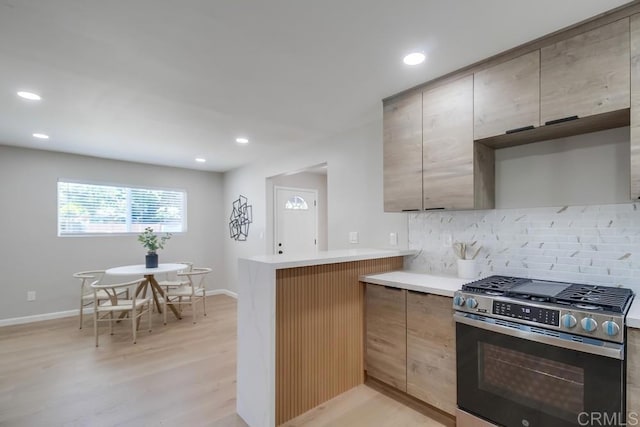 3629 Gilmore St, San Diego, CA 92113 - kitchen featuring stainless steel gas range oven, backsplash, a peninsula, light wood-style floors, and recessed lighting