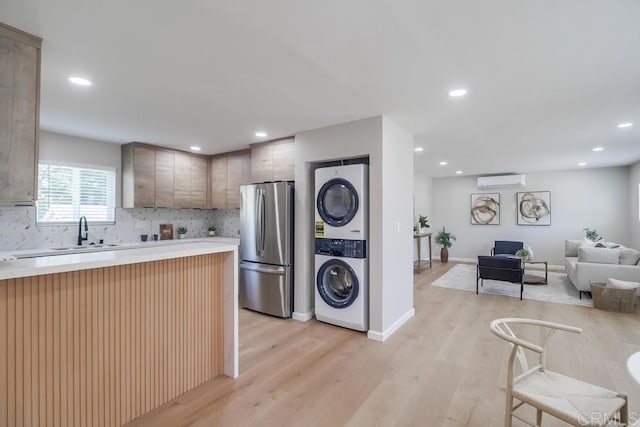 3629 Gilmore St, San Diego, CA 92113 - kitchen with freestanding refrigerator, stacked washing machine and dryer, a wall unit AC, open floor plan, and light countertops