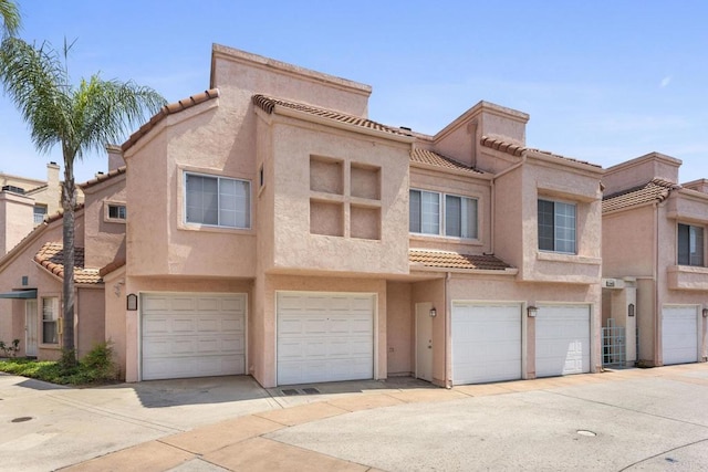 12032 Calle De Medio Unit 169, El Cajon, CA 92019 - townhome / multi-family property featuring a tile roof, an attached garage, stucco siding, and driveway