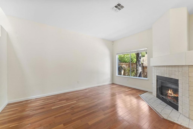 12032 Calle De Medio Unit 169, El Cajon, CA 92019 - unfurnished living room featuring a tile fireplace and wood finished floors