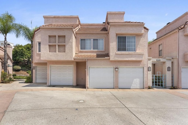 12032 Calle De Medio Unit 169, El Cajon, CA 92019 - townhome / multi-family property with a tiled roof, stucco siding, a chimney, and an attached garage
