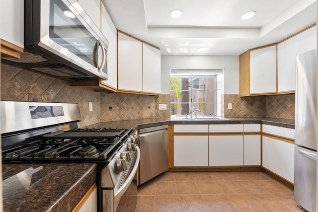 12032 Calle De Medio Unit 169, El Cajon, CA 92019 - kitchen featuring appliances with stainless steel finishes, a raised ceiling, white cabinetry, dark countertops, and light tile patterned floors