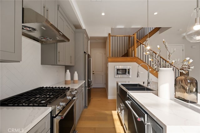 6023 Kauffman Ave, Temple City, CA 91780 - kitchen featuring appliances with stainless steel finishes, ventilation hood, gray cabinetry, light wood-style flooring, and decorative backsplash