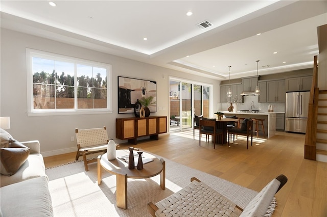 6023 Kauffman Ave, Temple City, CA 91780 - living area featuring healthy amount of natural light, light wood finished floors, a tray ceiling, and recessed lighting