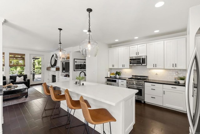 1480 Regatta Rd, Carlsbad, CA 92011 - kitchen with appliances with stainless steel finishes, tasteful backsplash, dark wood finished floors, white cabinets, and a breakfast bar
