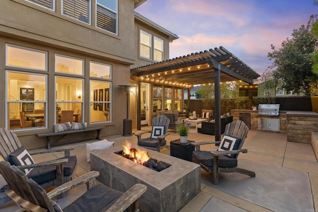 1480 Regatta Rd, Carlsbad, CA 92011 - patio terrace at dusk featuring exterior kitchen, a pergola, an outdoor living space with a fire pit, and a patio area