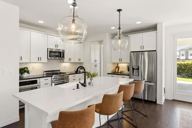 1480 Regatta Rd, Carlsbad, CA 92011 - kitchen featuring appliances with stainless steel finishes, backsplash, a kitchen bar, a center island with sink, and recessed lighting
