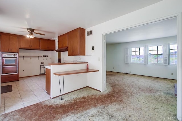 1970 El Prado Ave, Lemon Grove, CA 91945 - kitchen with a peninsula, brown cabinets, ceiling fan, open floor plan, and a breakfast bar