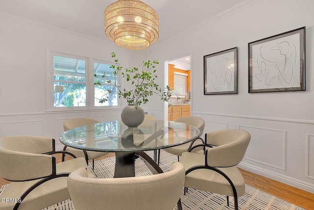 3671 Grayburn Rd, Pasadena, CA 91107 - dining area with a decorative wall, ornamental molding, light wood-type flooring, a chandelier, and a wainscoted wall