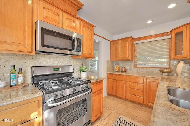 3671 Grayburn Rd, Pasadena, CA 91107 - kitchen with stainless steel appliances, tasteful backsplash, light tile patterned floors, glass insert cabinets, and light stone countertops