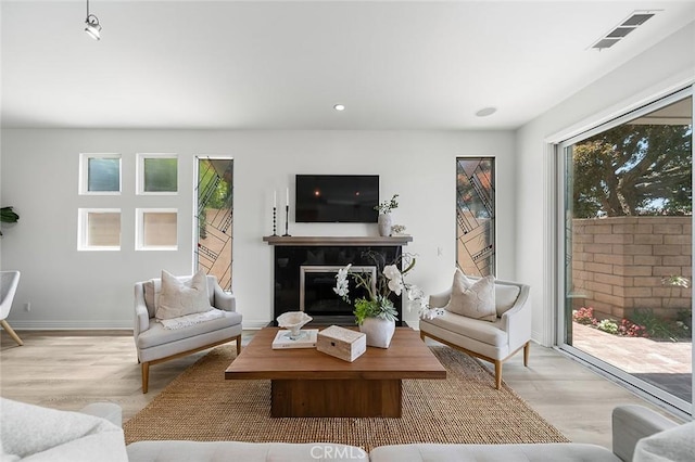 3496 Windspun, Huntington Beach, CA 92649 - living area featuring a glass covered fireplace, light wood-style flooring, and recessed lighting