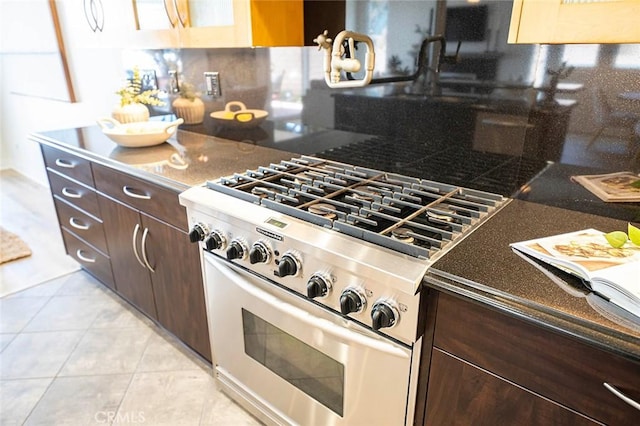 3496 Windspun, Huntington Beach, CA 92649 - kitchen featuring high end stainless steel range, dark brown cabinetry, backsplash, and light tile patterned floors