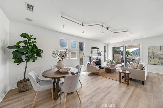 3496 Windspun, Huntington Beach, CA 92649 - dining area with light wood-style flooring and a glass covered fireplace