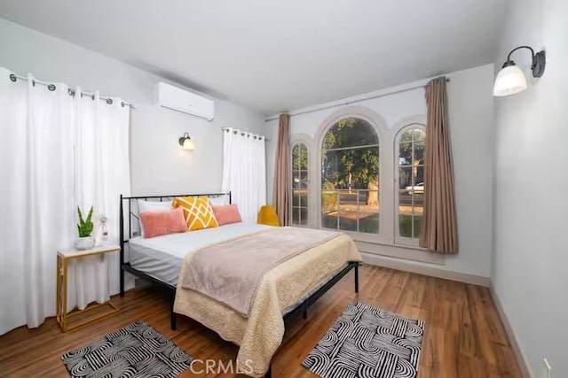 5743 Magnolia Ave, Riverside, CA 92506 - bedroom featuring a wall mounted AC and wood finished floors