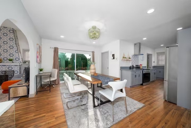 5743 Magnolia Ave, Riverside, CA 92506 - dining space featuring wood finished floors, a chandelier, recessed lighting, and arched walkways