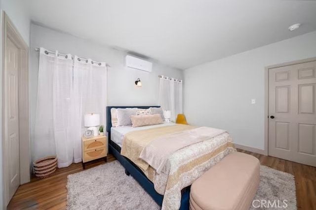 5743 Magnolia Ave, Riverside, CA 92506 - bedroom featuring an AC wall unit and wood finished floors
