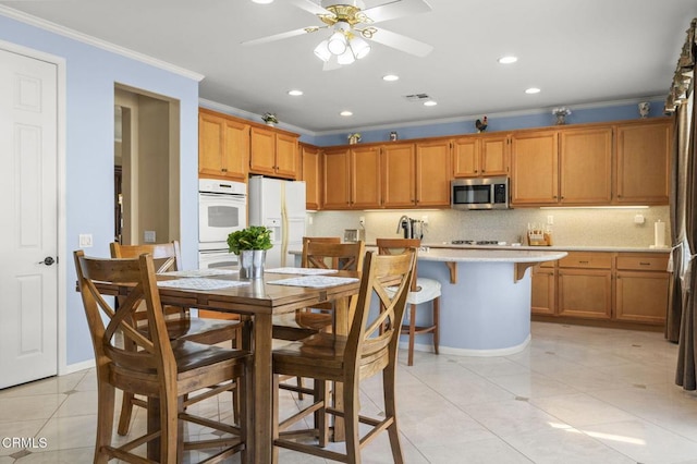 1776 Marsala Way, Camarillo, CA 93012 - kitchen with stainless steel microwave, white fridge with ice dispenser, ornamental molding, light countertops, and recessed lighting
