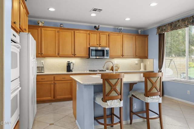 1776 Marsala Way, Camarillo, CA 93012 - kitchen with white appliances, decorative backsplash, an island with sink, light tile patterned floors, and crown molding
