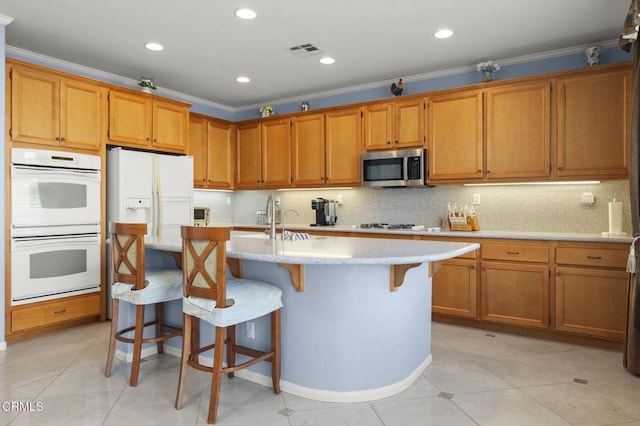 1776 Marsala Way, Camarillo, CA 93012 - kitchen featuring white double oven, stainless steel microwave, brown cabinets, ornamental molding, and recessed lighting