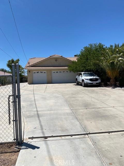 15805 Muscatel St, Hesperia, CA 92345 - mediterranean / spanish house featuring stucco siding, a tile roof, concrete driveway, and a garage